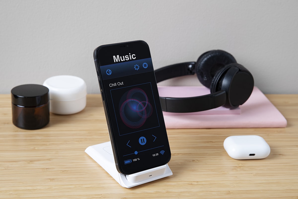 high-angle-smartphone-desk-with-headphones-min