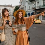 stylish-young-women-traveling-together-europe-dressed-spring-trendy-dresses-accessories-min